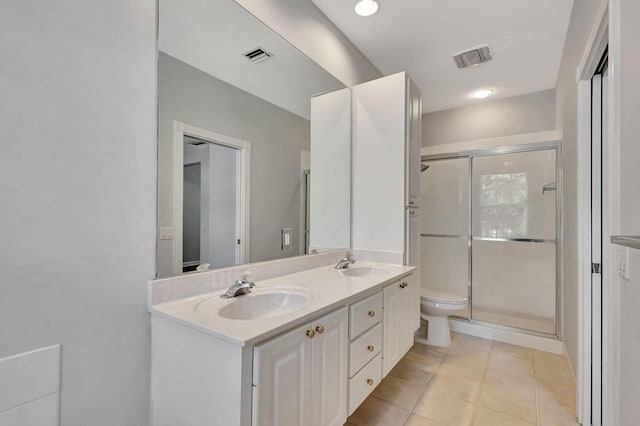 bathroom with tile patterned flooring, vanity, toilet, and a shower with shower door