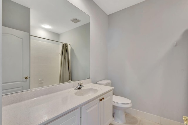 bathroom with a shower with curtain, tile patterned flooring, vanity, and toilet