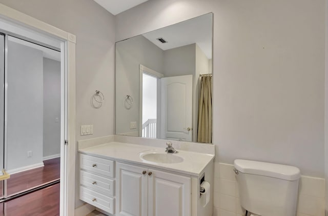 bathroom with hardwood / wood-style floors, vanity, and toilet