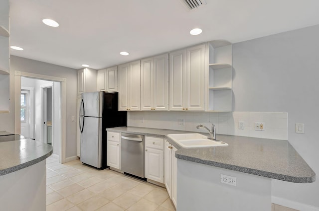 kitchen featuring white cabinets, sink, light tile patterned floors, kitchen peninsula, and stainless steel appliances