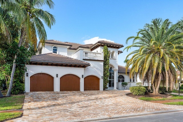 mediterranean / spanish home featuring a balcony and a garage