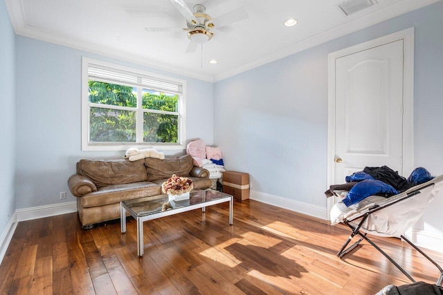 living area featuring ceiling fan, wood-type flooring, and ornamental molding