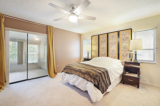 bedroom with a textured ceiling, light colored carpet, and ceiling fan