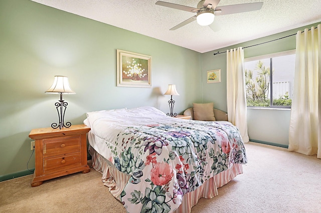 bedroom featuring light carpet, a textured ceiling, and ceiling fan