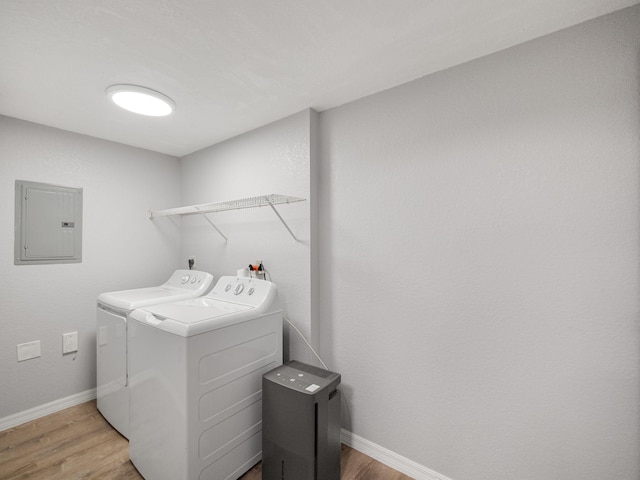 laundry room with electric panel, separate washer and dryer, and hardwood / wood-style floors