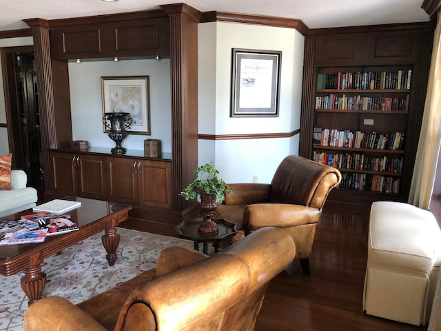 living area with dark hardwood / wood-style flooring and crown molding