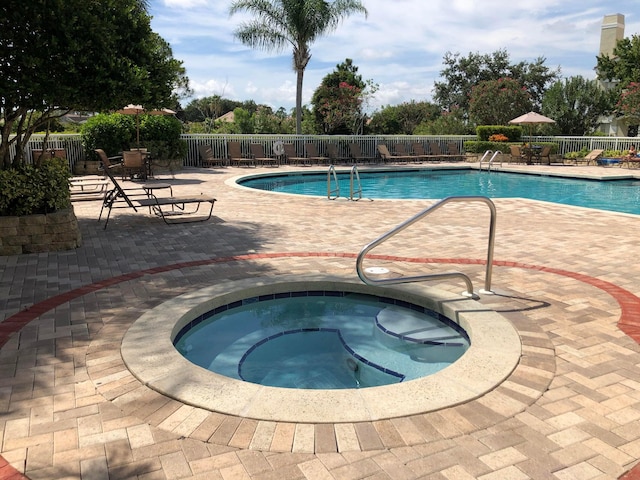 view of pool featuring a community hot tub and a patio