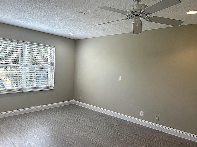 spare room with baseboards, a textured ceiling, wood finished floors, and a ceiling fan