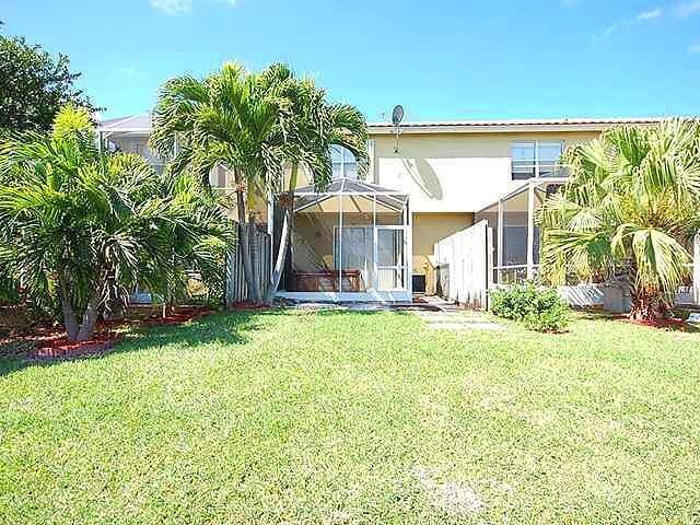 back of property featuring a yard and a lanai