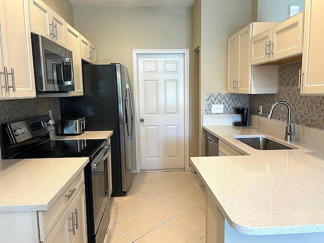 kitchen featuring backsplash, sink, appliances with stainless steel finishes, light tile patterned flooring, and kitchen peninsula