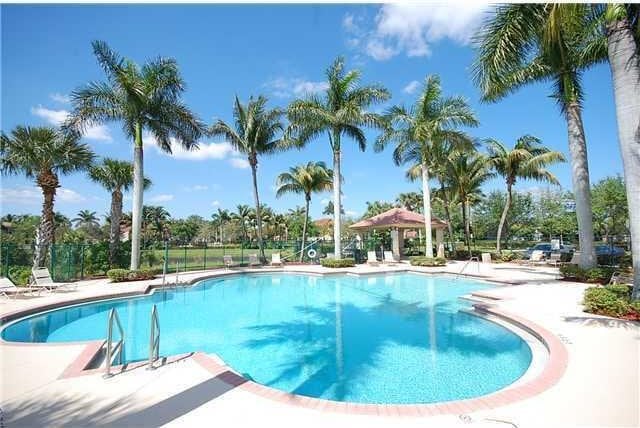 community pool with a gazebo, a patio, and fence