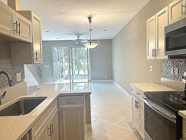 kitchen with stainless steel microwave, light countertops, light tile patterned floors, black electric range, and a sink