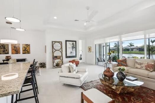 living room featuring ceiling fan and a water view