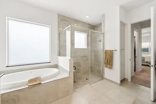 bathroom with tile patterned floors and independent shower and bath