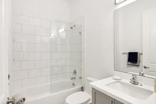 full bathroom with vanity, tiled shower / bath combo, and toilet