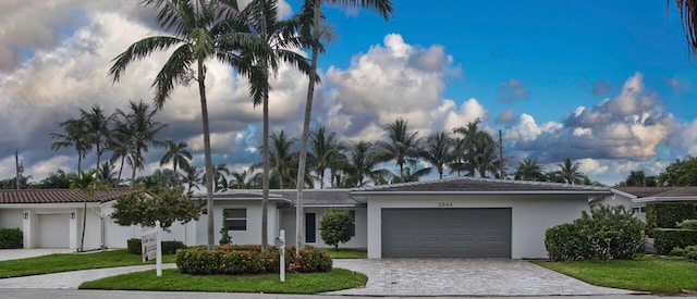 view of front of house featuring a front lawn and a garage