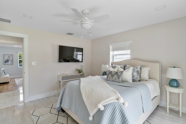 bedroom featuring multiple windows, ceiling fan, and light hardwood / wood-style floors