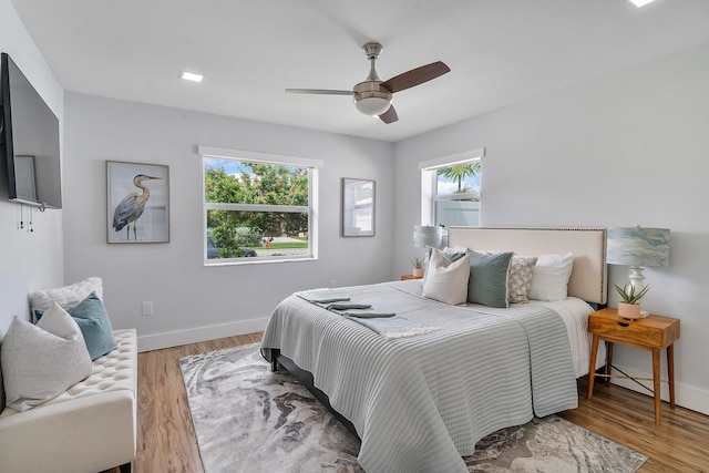 bedroom featuring multiple windows, ceiling fan, and wood-type flooring