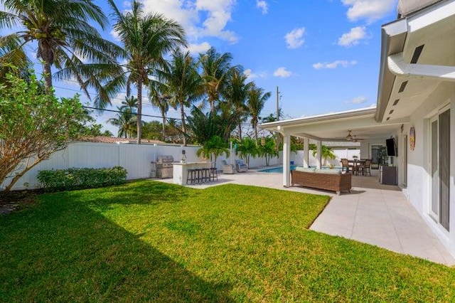 view of yard with an outdoor hangout area, exterior bar, ceiling fan, a patio area, and a fenced in pool