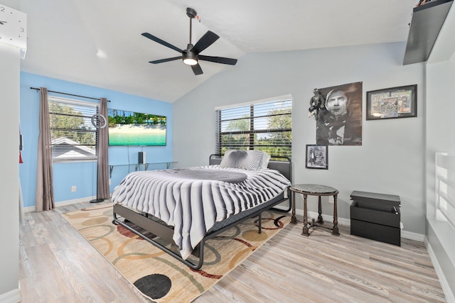 bedroom with light wood-type flooring, multiple windows, baseboards, and lofted ceiling