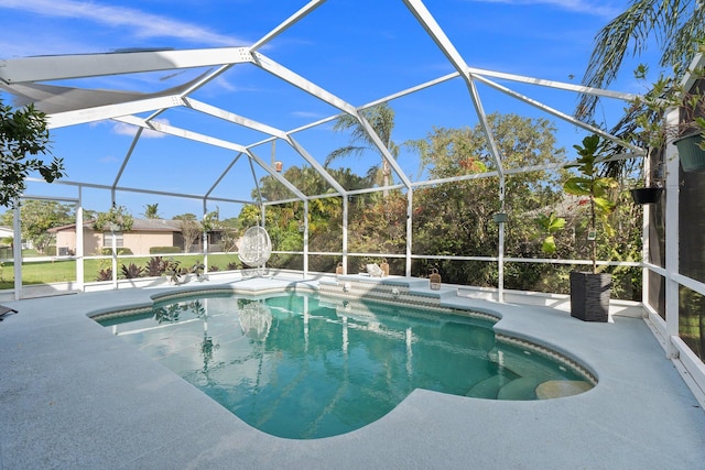 pool featuring glass enclosure and a patio