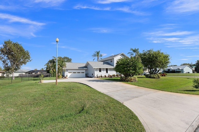 view of front of property with a garage, driveway, a front yard, and fence