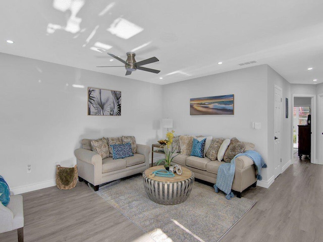 living room with ceiling fan and light wood-type flooring