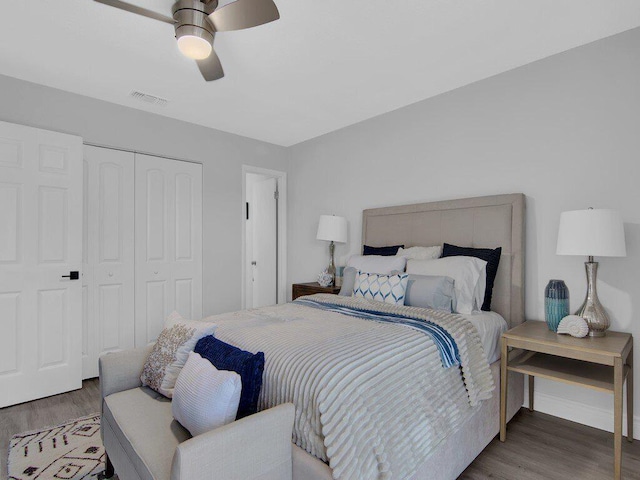 bedroom with dark hardwood / wood-style floors, ceiling fan, and a closet