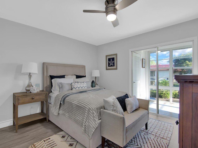 bedroom featuring access to exterior, ceiling fan, a water view, and light hardwood / wood-style floors