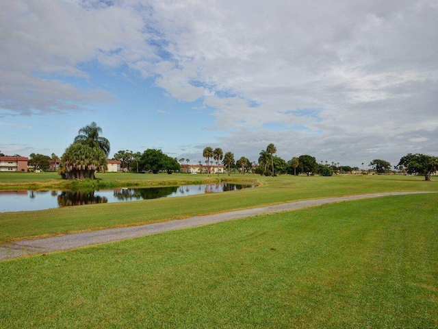 view of property's community featuring a lawn and a water view