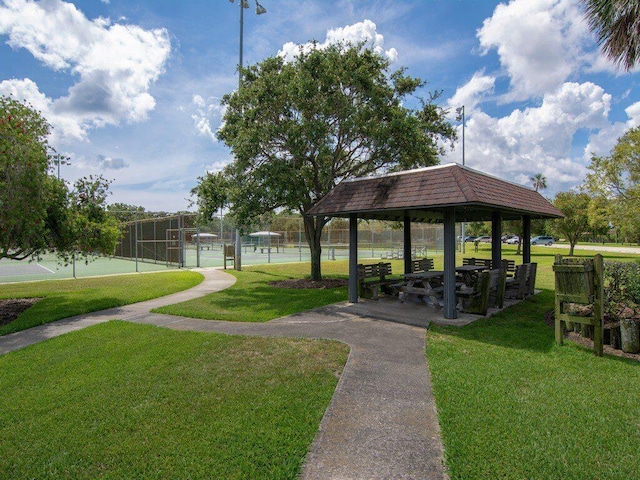 surrounding community with a gazebo, tennis court, and a yard