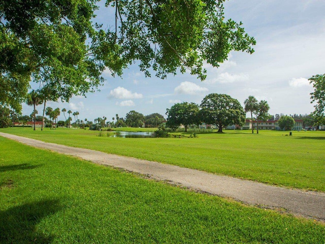 surrounding community featuring a lawn and a water view