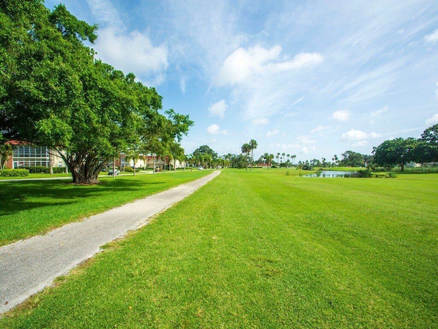 surrounding community featuring a lawn and a water view