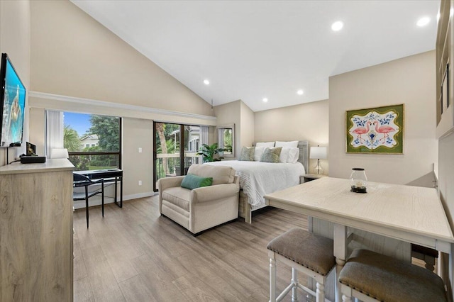 bedroom featuring access to exterior, high vaulted ceiling, and light hardwood / wood-style flooring