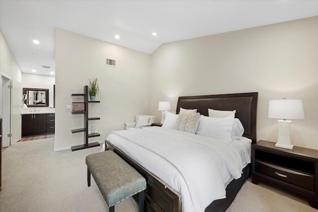 carpeted bedroom featuring ensuite bath