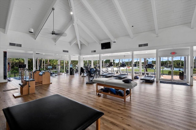 gym featuring ceiling fan, hardwood / wood-style floors, and high vaulted ceiling