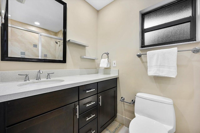 bathroom with vanity, toilet, and a shower with shower door