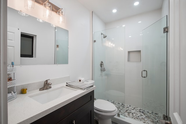 bathroom featuring walk in shower, vanity, and toilet