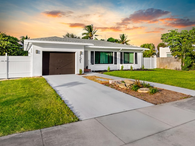 view of front of home with a garage and a yard