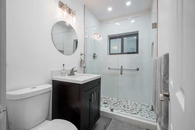 bathroom featuring vanity, hardwood / wood-style flooring, toilet, and an enclosed shower