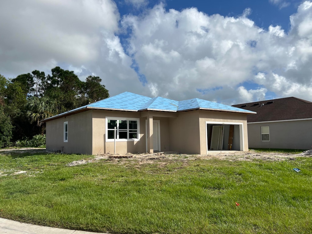 rear view of house featuring a lawn