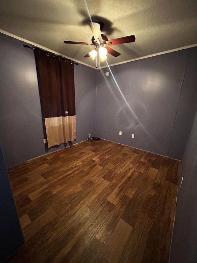 unfurnished bedroom featuring dark wood-type flooring, ornamental molding, and a textured ceiling