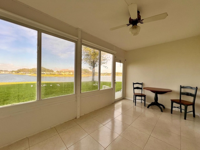 sunroom / solarium featuring ceiling fan and a water view