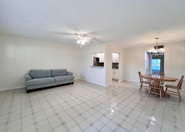 tiled living room featuring ceiling fan with notable chandelier