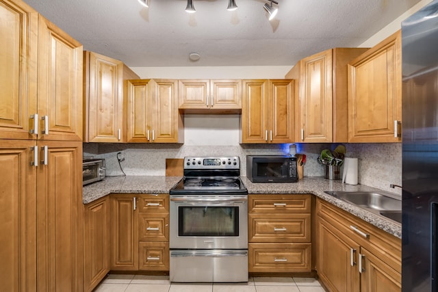 kitchen featuring light tile patterned floors, stainless steel range with electric cooktop, and stone counters