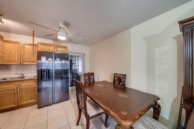 dining area with light tile patterned floors, ceiling fan, and sink