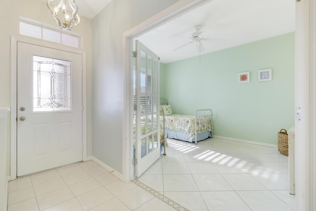 foyer with light tile patterned floors and ceiling fan with notable chandelier