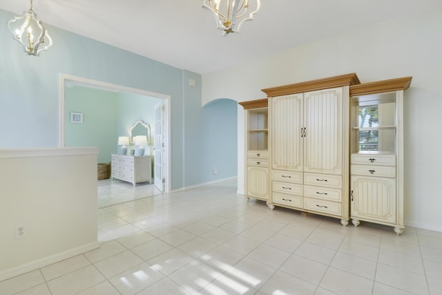 unfurnished bedroom featuring a notable chandelier and light tile patterned floors