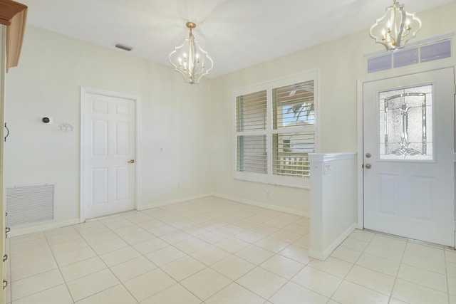 tiled entrance foyer featuring a chandelier and a wealth of natural light