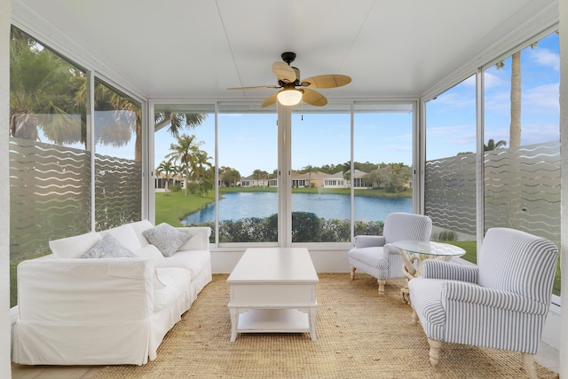 sunroom featuring plenty of natural light, ceiling fan, and a water view